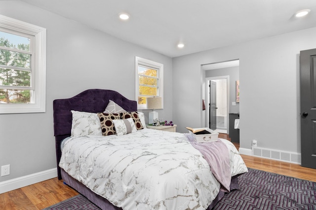 bedroom with multiple windows and dark hardwood / wood-style flooring