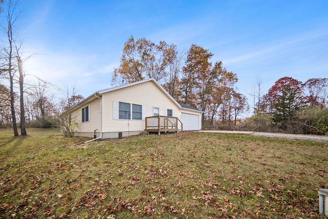 rear view of property featuring a garage and a lawn