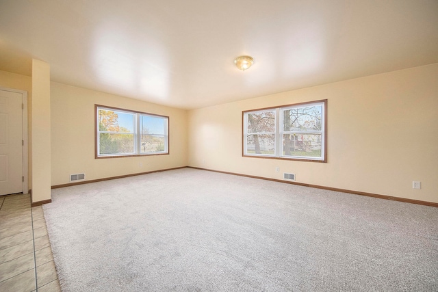 unfurnished room featuring light carpet