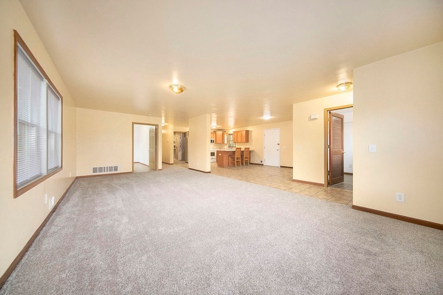 unfurnished living room with light colored carpet