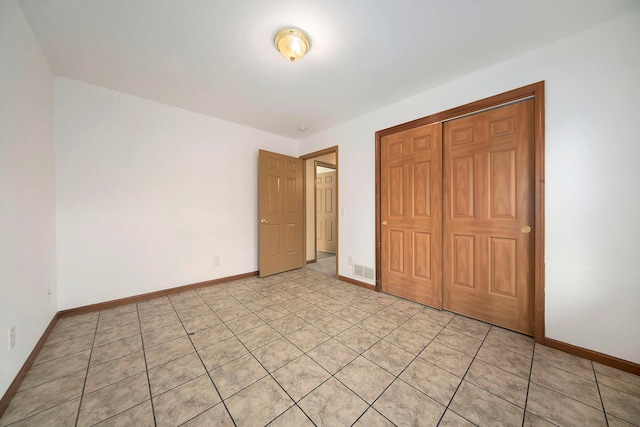 unfurnished bedroom featuring a closet and light tile patterned floors