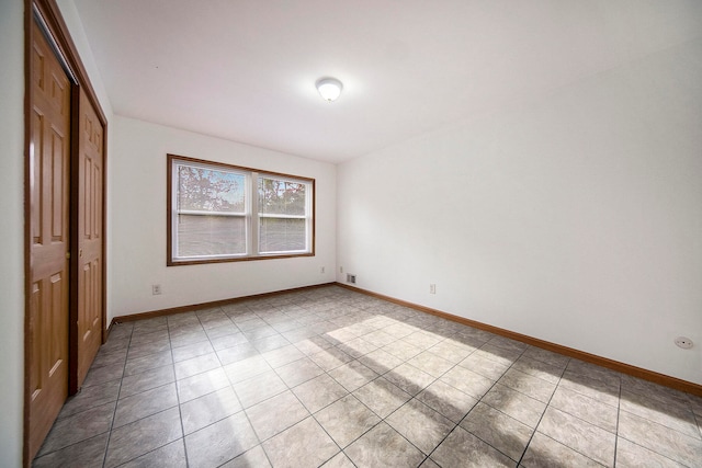 unfurnished bedroom featuring light tile patterned flooring and a closet