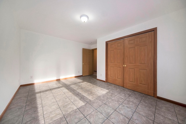 unfurnished bedroom with a closet and light tile patterned flooring