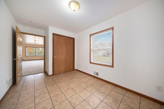 unfurnished bedroom with a closet and light tile patterned floors