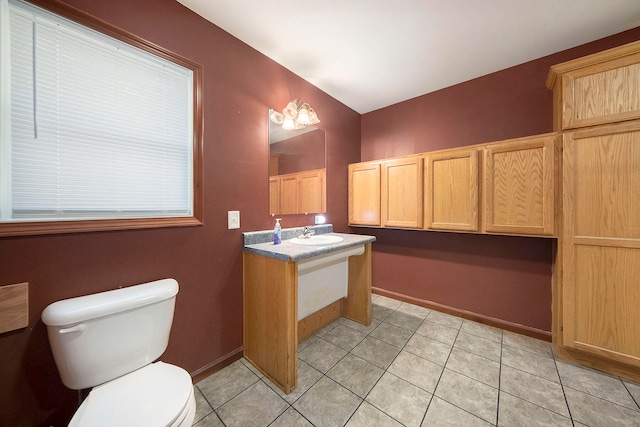 bathroom with toilet, vanity, and tile patterned flooring