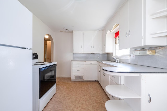 kitchen featuring decorative backsplash, sink, white cabinetry, range with electric stovetop, and white refrigerator