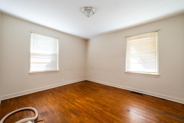 unfurnished room with dark hardwood / wood-style flooring