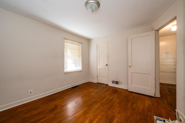 unfurnished bedroom with dark hardwood / wood-style floors