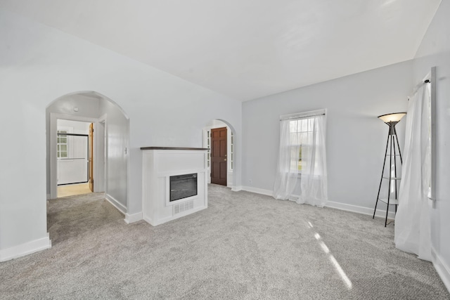 unfurnished living room featuring light colored carpet