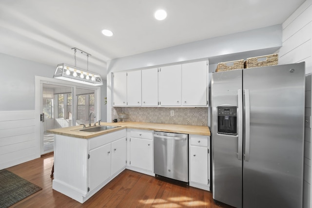 kitchen featuring appliances with stainless steel finishes, white cabinetry, and dark hardwood / wood-style flooring