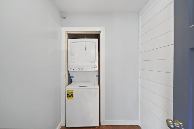 laundry area featuring hardwood / wood-style floors and stacked washer / dryer