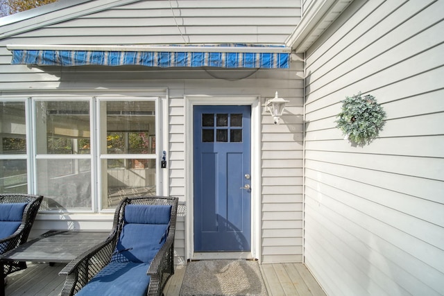 view of exterior entry with a wooden deck