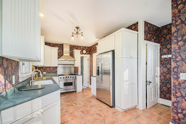 kitchen with stainless steel appliances, white cabinetry, sink, and wall chimney exhaust hood