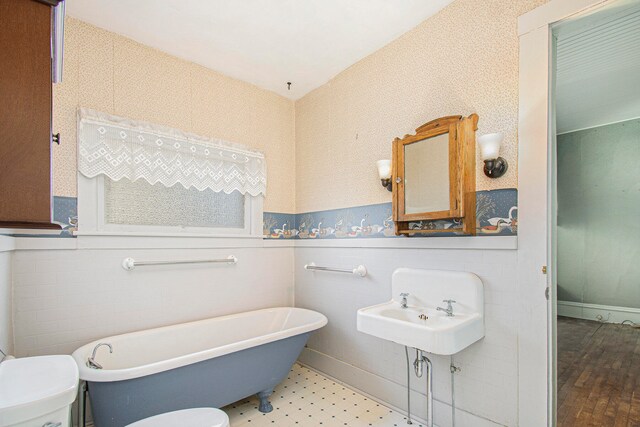 bathroom featuring toilet, sink, and a bathing tub