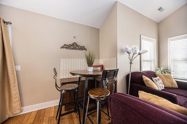 dining room featuring lofted ceiling and hardwood / wood-style floors