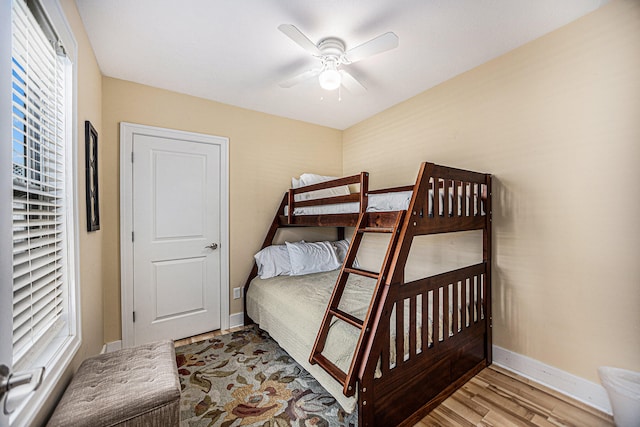 bedroom featuring multiple windows, wood-type flooring, and ceiling fan