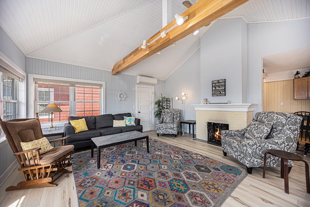 living room featuring beam ceiling, high vaulted ceiling, light wood-type flooring, and a fireplace