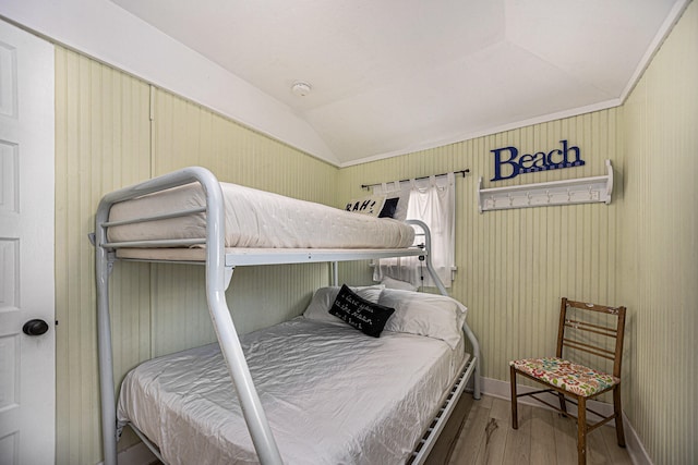 bedroom with wood-type flooring and vaulted ceiling