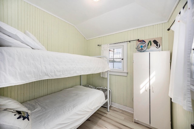 bedroom with light hardwood / wood-style floors and lofted ceiling