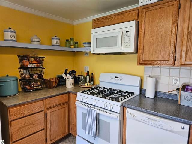 kitchen with crown molding, backsplash, and white appliances