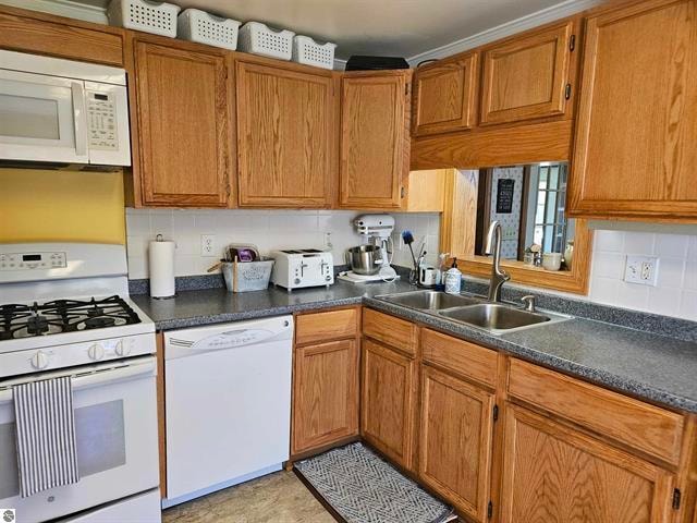 kitchen with decorative backsplash, sink, and white appliances