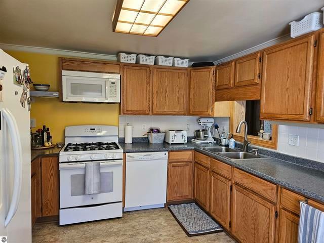 kitchen featuring sink, crown molding, white appliances, and tasteful backsplash