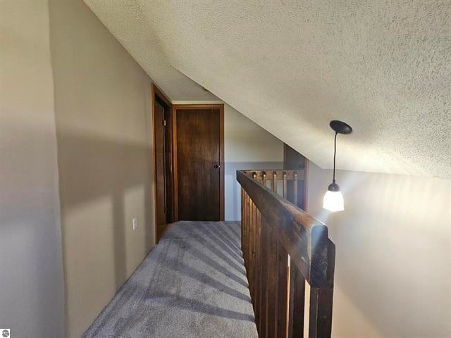 carpeted bedroom featuring lofted ceiling and a textured ceiling