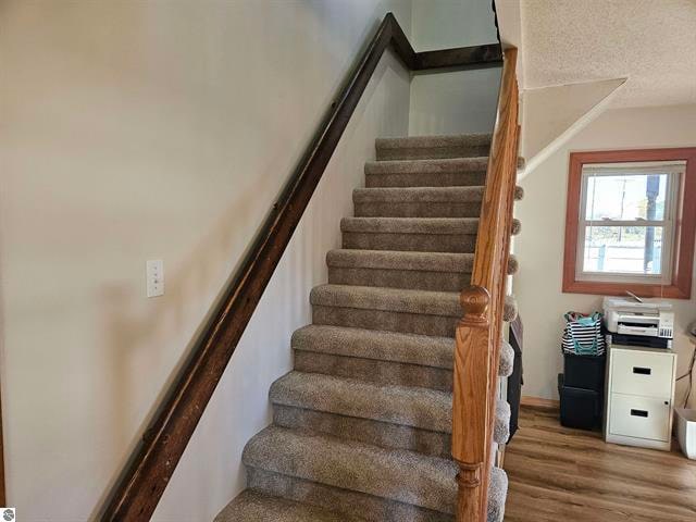 stairs featuring hardwood / wood-style flooring