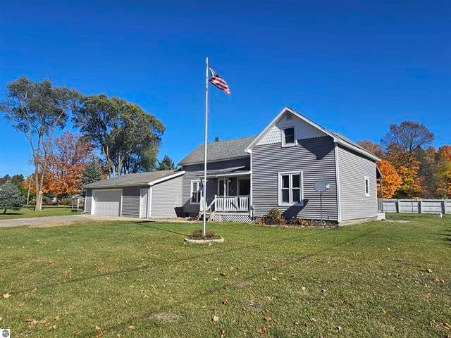 view of front of house with a front yard, a porch, and a garage