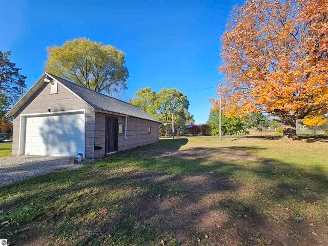 view of property exterior with a garage and a lawn