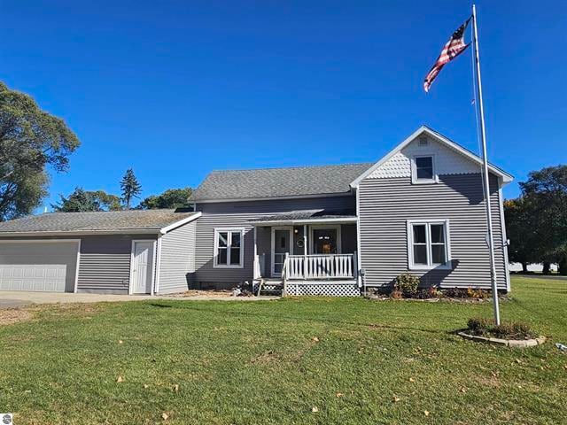 view of front property with covered porch, a front lawn, and a garage