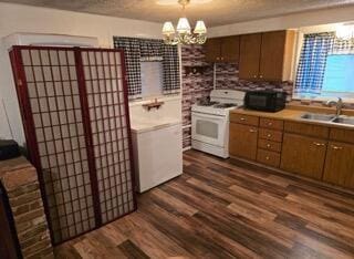 kitchen with dark wood-type flooring, an inviting chandelier, sink, hanging light fixtures, and white range oven