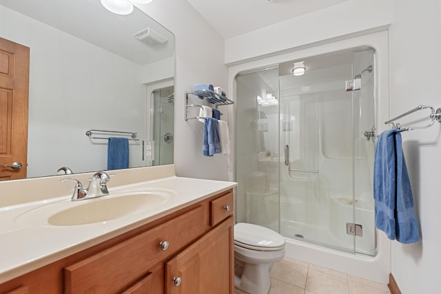 bathroom featuring vanity, a shower with shower door, toilet, and tile patterned floors