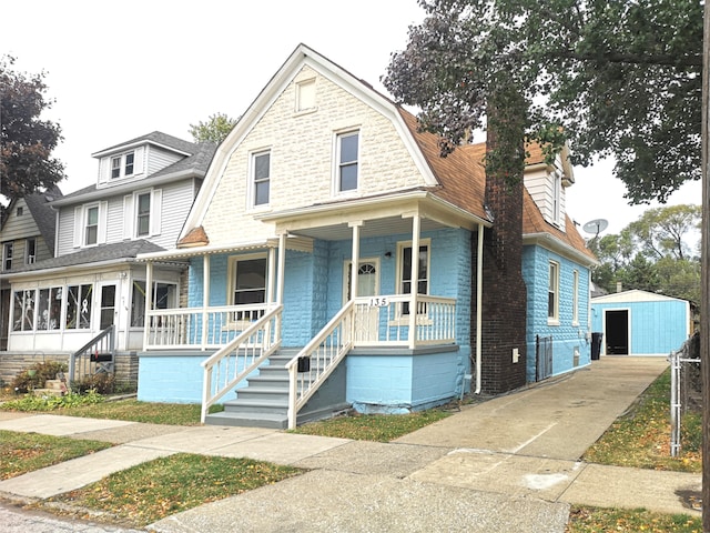 view of front of house featuring a storage unit and a porch