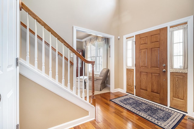 entrance foyer with crown molding and hardwood / wood-style floors