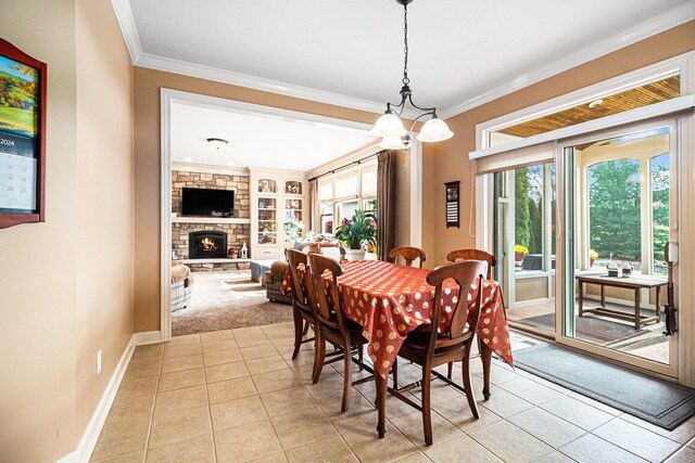 dining space with a stone fireplace, ornamental molding, light tile patterned floors, and built in shelves