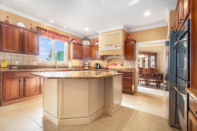 kitchen featuring light tile patterned flooring, a center island, decorative backsplash, light stone counters, and ornamental molding