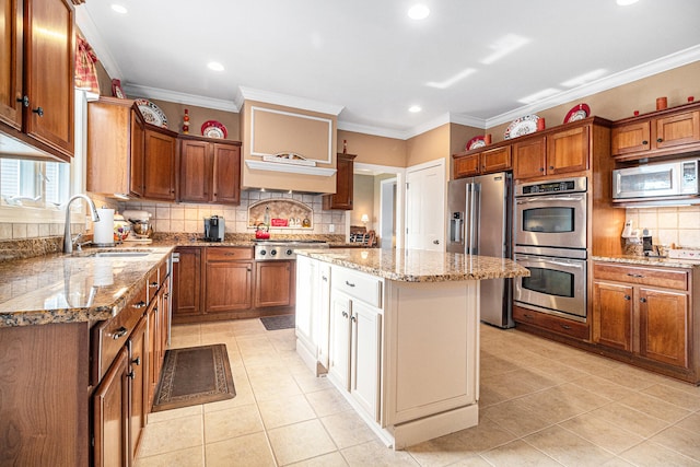 kitchen featuring stainless steel appliances, crown molding, sink, a center island, and light stone counters