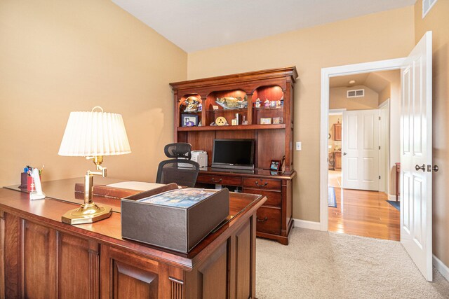 carpeted office space featuring vaulted ceiling