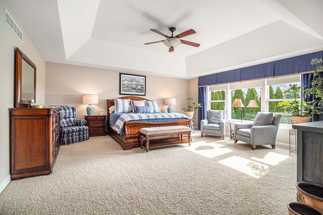 bedroom featuring carpet, a tray ceiling, and ceiling fan