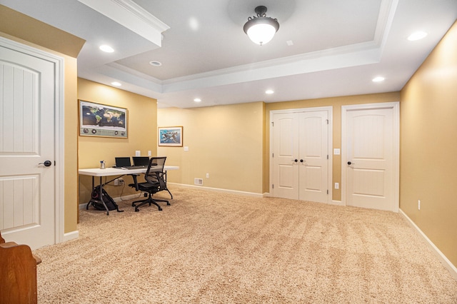 carpeted home office featuring ornamental molding and a raised ceiling