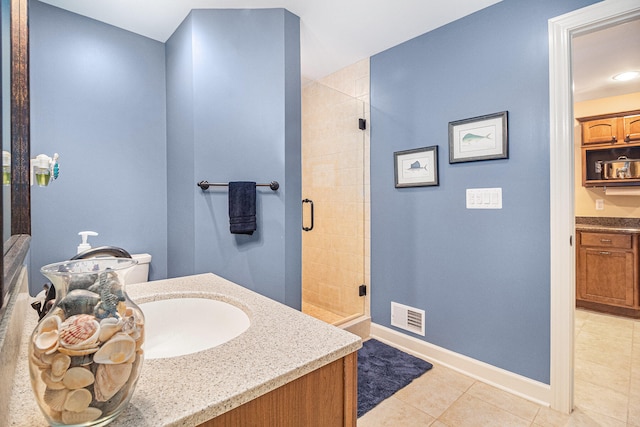 bathroom with a shower with door, tile patterned floors, vanity, and toilet