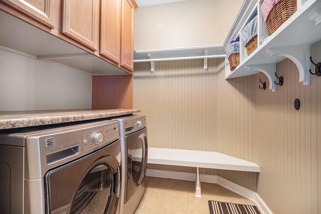 laundry area with cabinets, washer and clothes dryer, and light tile patterned floors