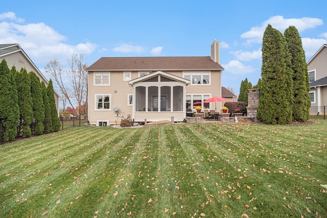 back of property with a patio, a yard, and a sunroom