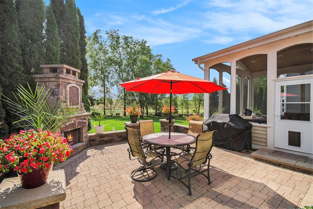 view of patio with an outdoor fireplace and a grill