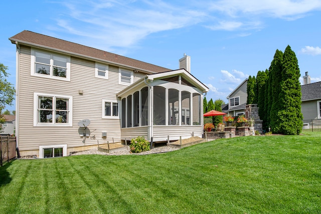 back of property with a lawn and a sunroom