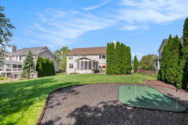 back of property featuring a yard and a sunroom