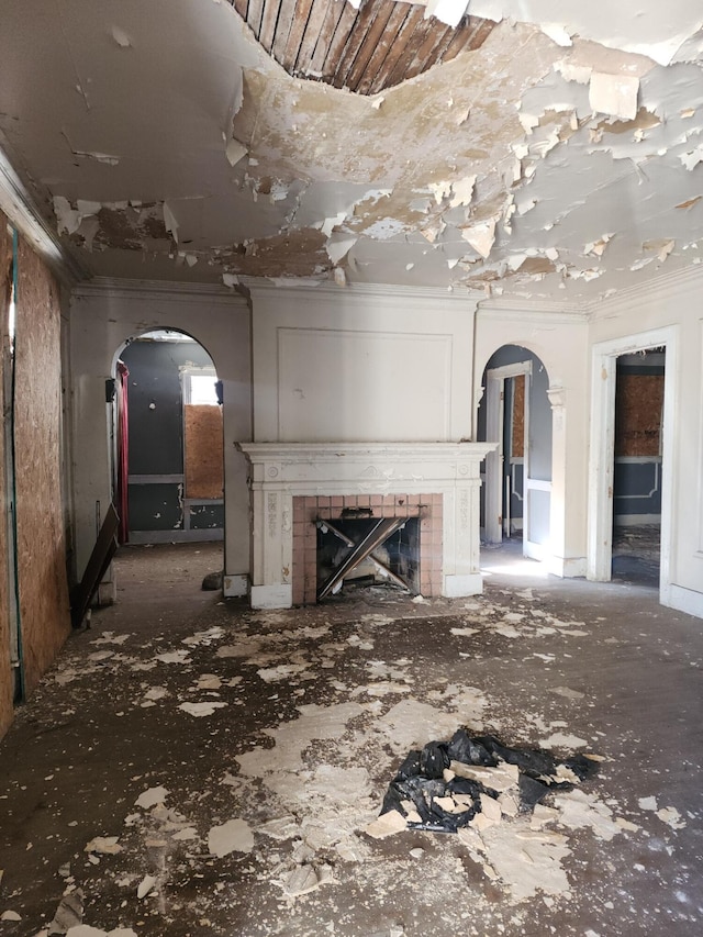 unfurnished living room featuring crown molding and a tile fireplace