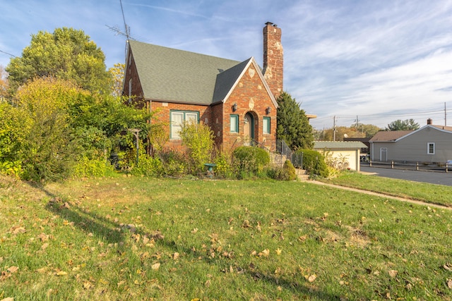 english style home featuring a front lawn and a garage