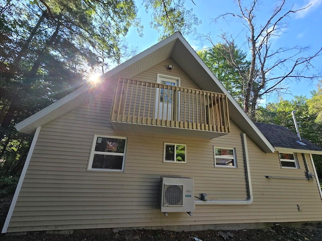 back of property featuring ac unit and a balcony